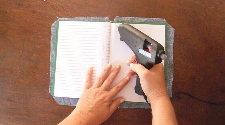 cuaderno abierto y pistola de silicona