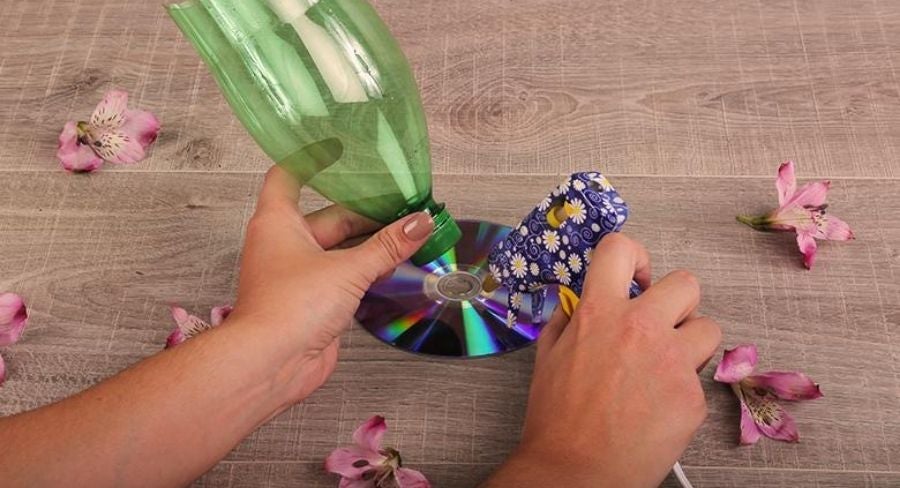 Pegando un disco a una botella de plastico reciclada pegar el CD