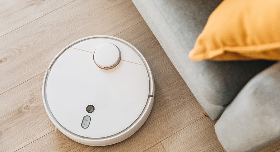 robot aspirador limpiando el piso de madera en la sala de estar