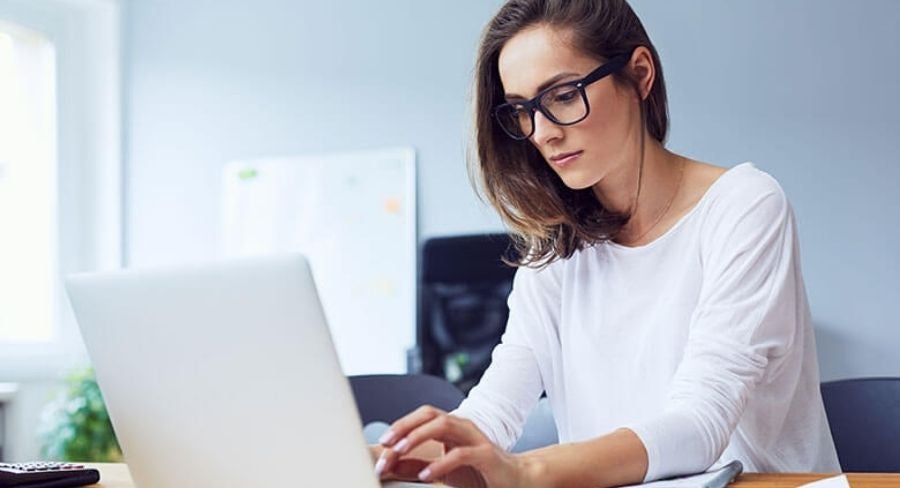 Mujer escribiendo en un computador pórtatil