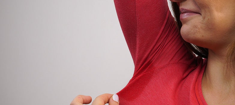 Mujer con una mancha de sudor en una prenda de ropa