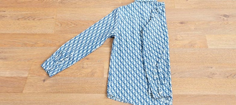 camisa azul de caballos de mar doblada por detras