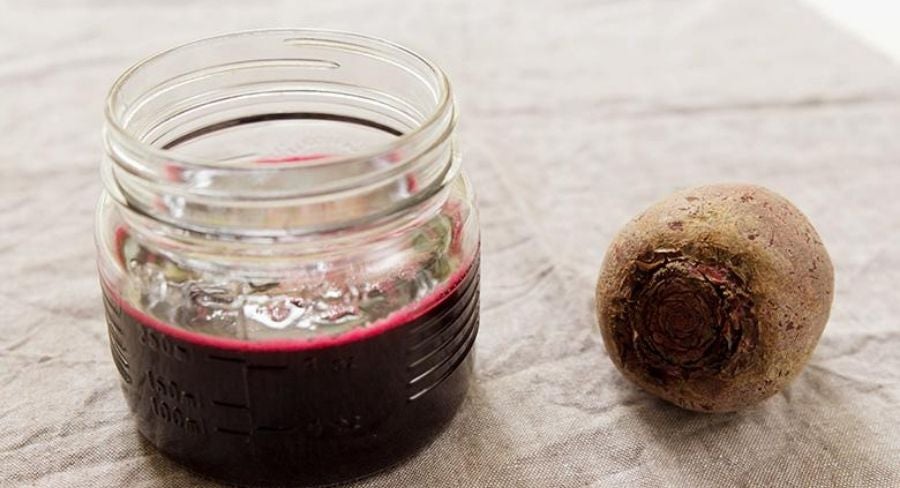 Jugo betabel en recipiente con su fruta