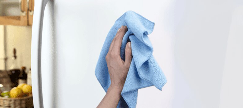 Mujer retirando alimentos en mal estado del refrigerador.