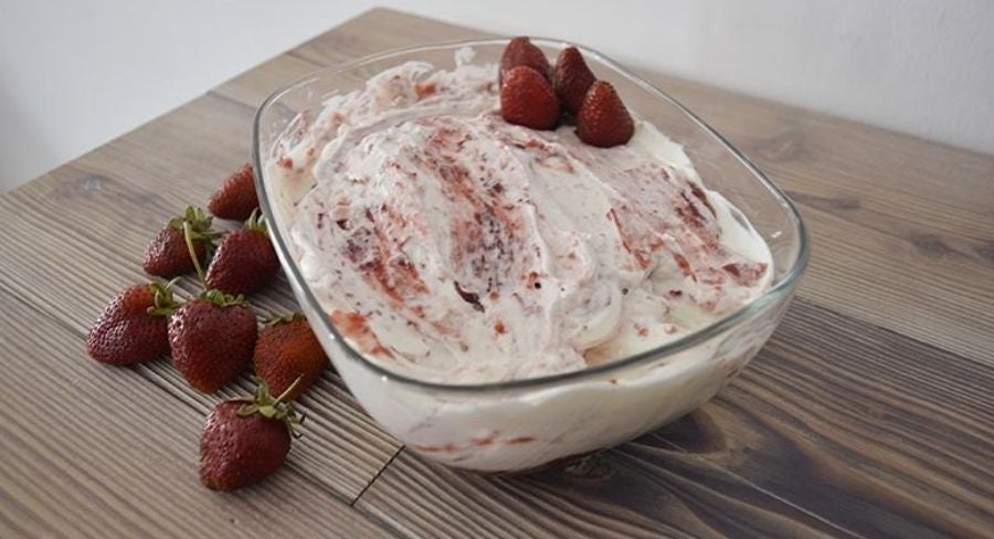 Helado cremoso con fresas listo para su degustación helado en recipiente con fresas