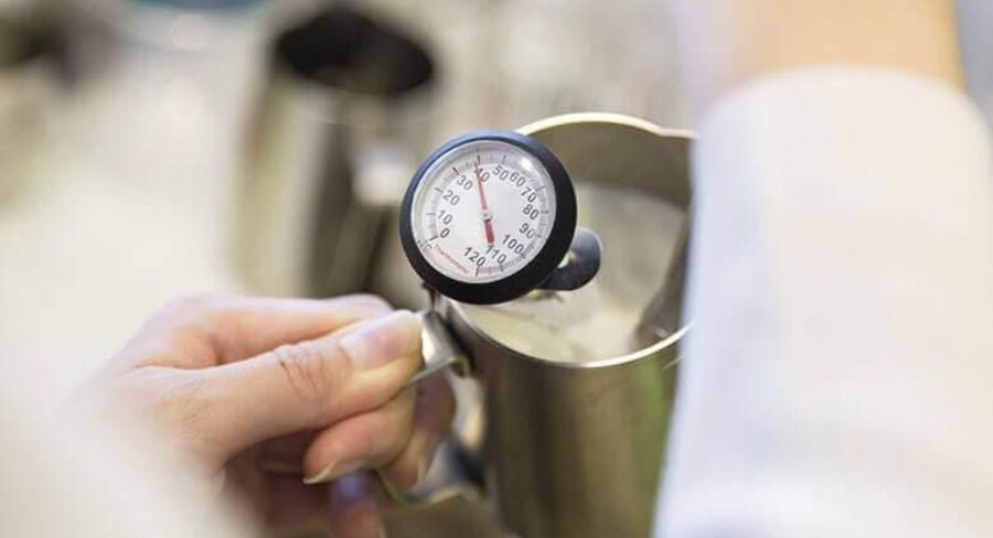 Termómetro en olla para controlar la temperatura al pasteurizar leche