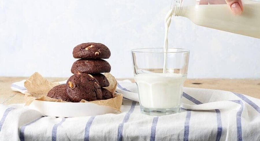 Leche recién hervida servida junto a galletas en una mesa casera