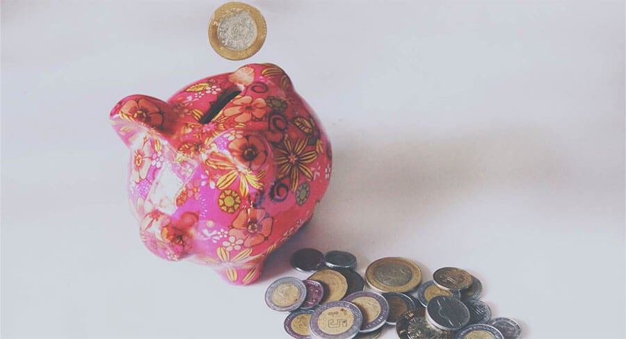 alcancía con monedas alrededor
