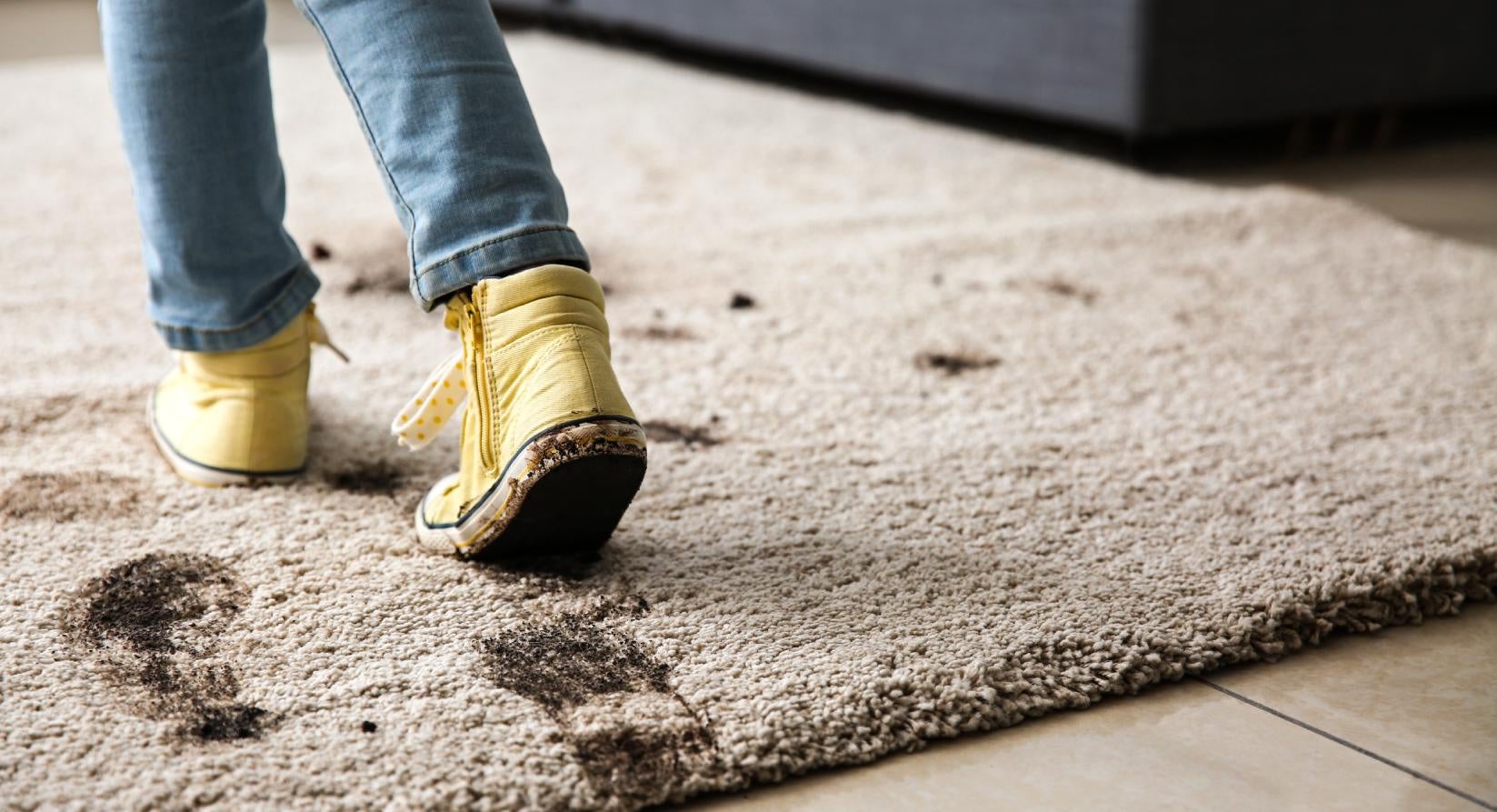 Tapete de sala sujo por pisada de criança com os tênis sujos de lama 