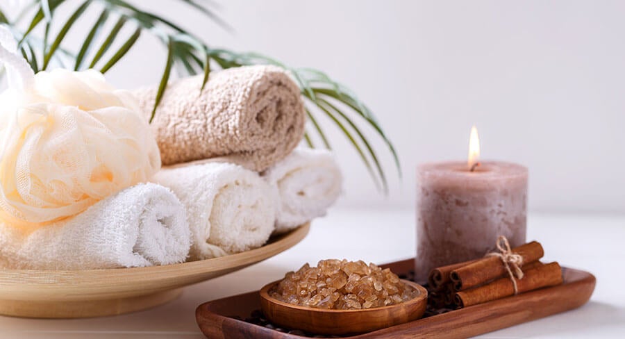 vela aromática, sal de baño y toallas evocando ambiente de spa