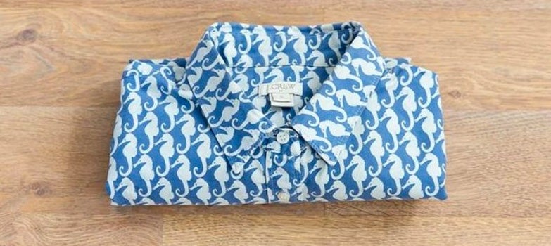 camisa azul de caballos marinos doblada de forma muy pequeña