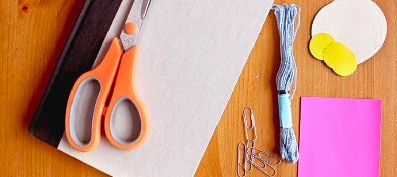 cuaderno-y-tijeras-naranjas.jpg Materiales para realizar un separador en casa