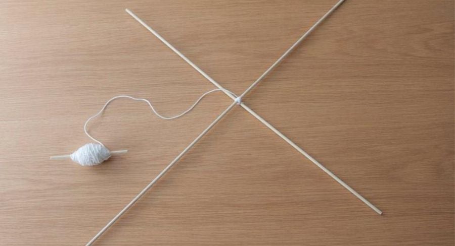 Palos de madera en equis e hilo grueso