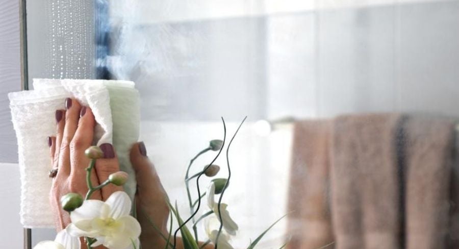 mano-limpiando-un-espejo.jpg limpiar el espejo o ventana con el papel humedecido con alcohol